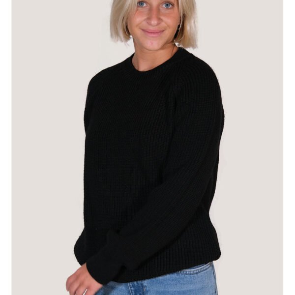 Sisstrevolution Barra Crew Sweater in black, worn by a model with jeans.