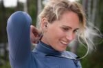Woman wearing SurfEars 4.0 ear plugs while surfing outdoors.