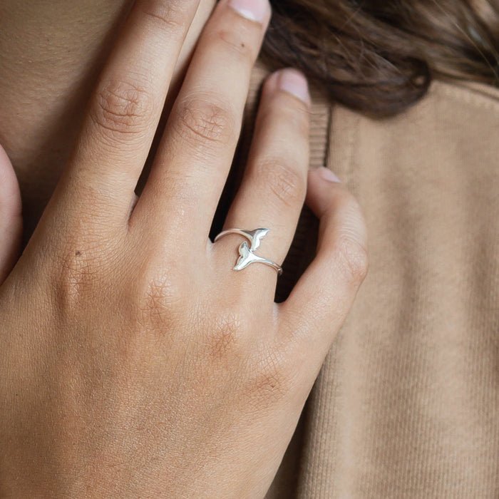 Silver whale tail wrap ring worn on a hand, showcasing elegant design.
